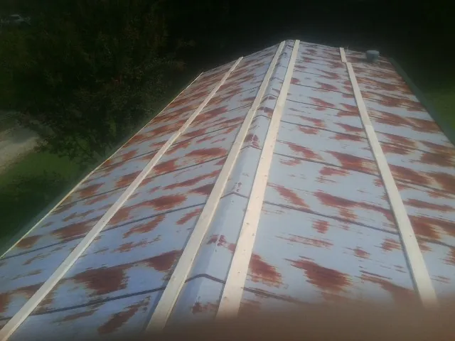 Rusted metal roof panels with new wood purlins before replacement — Storm Damage Roof Repair in Golden by Roofing Brothers