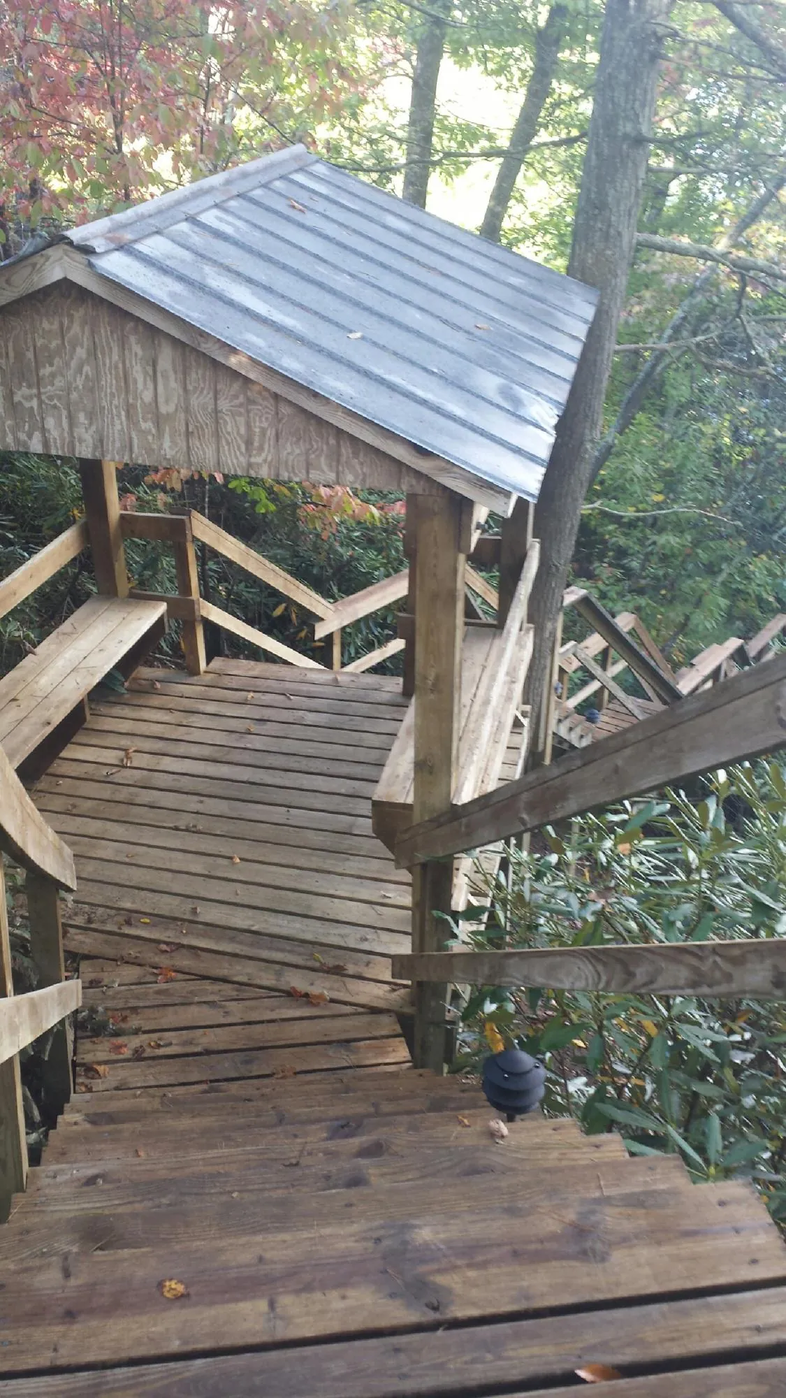 Metal roofed shelter over wooden steps on a wooded walkway — Skylight Repair & Installation work by our crew in Golden