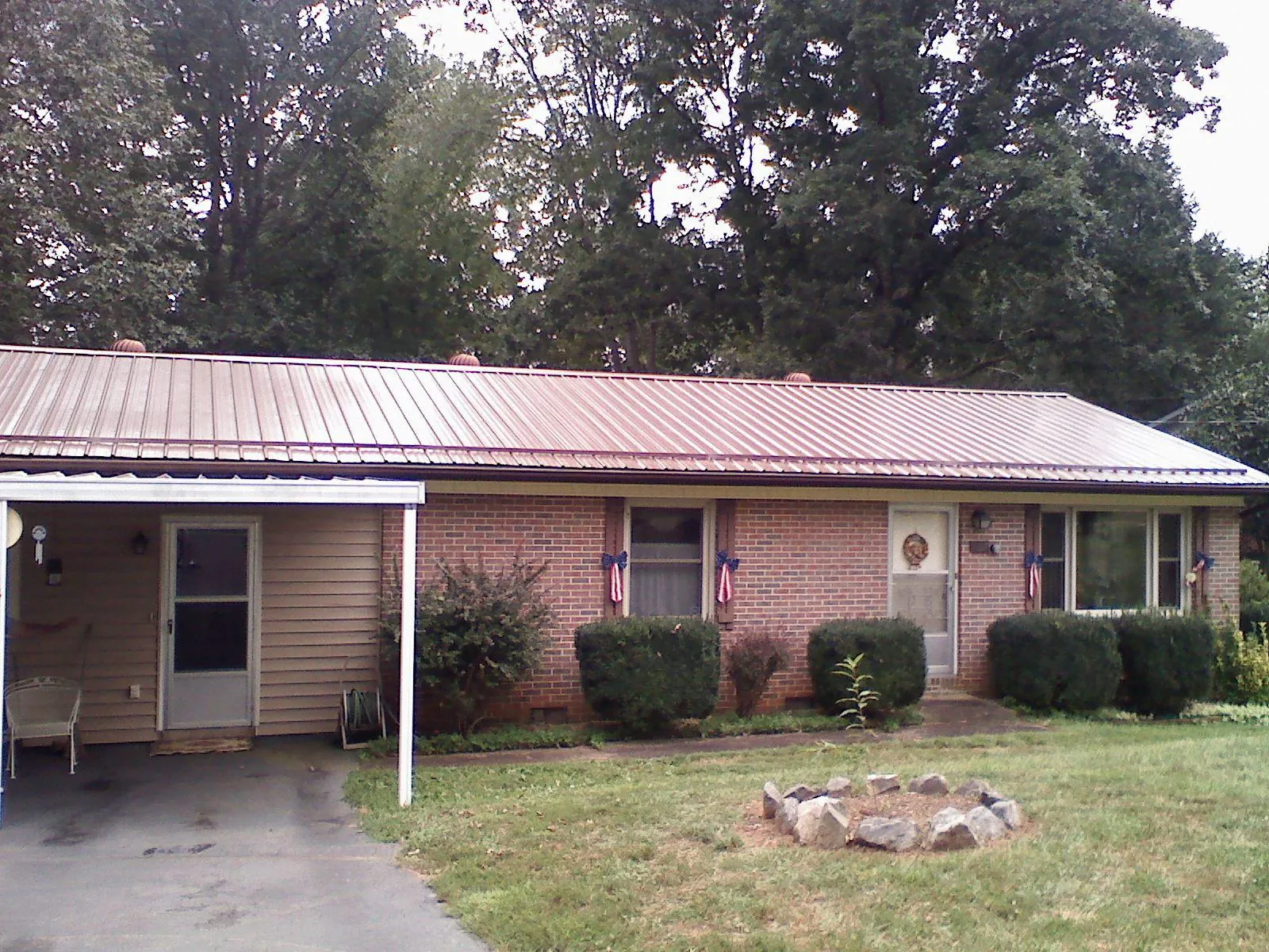 Bronze metal roof and carport on a brick ranch home — Roof Repair work by our crew in Golden